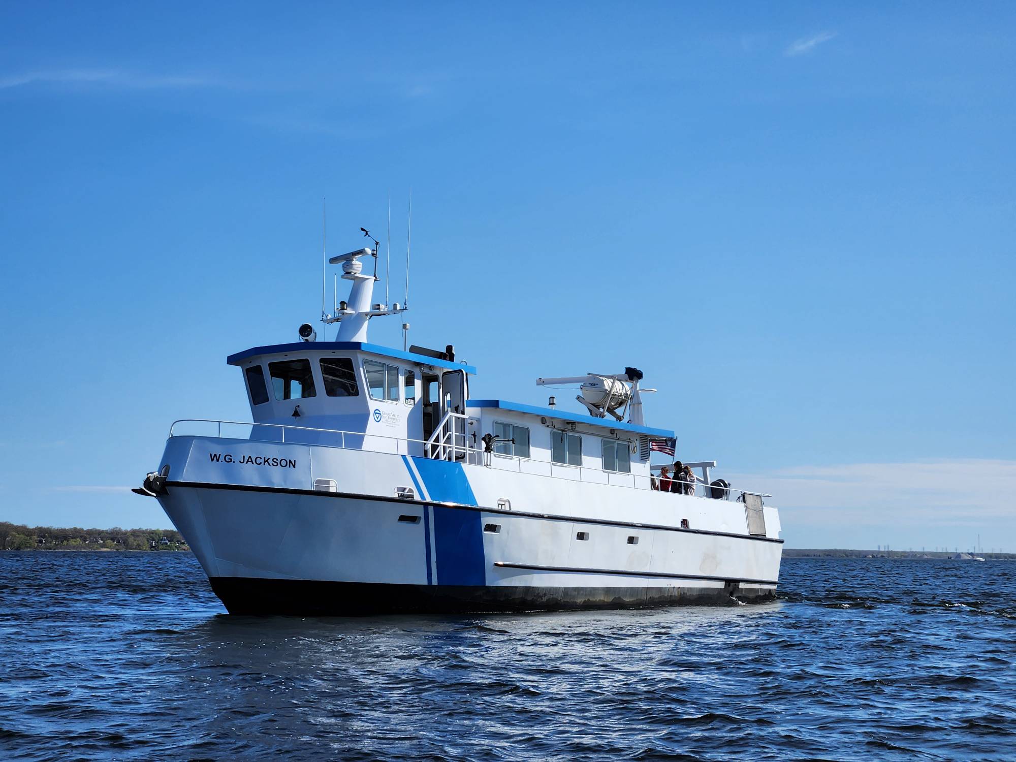 W.G. Jackson Research and Education vessel cruising on lake with blue sky in background